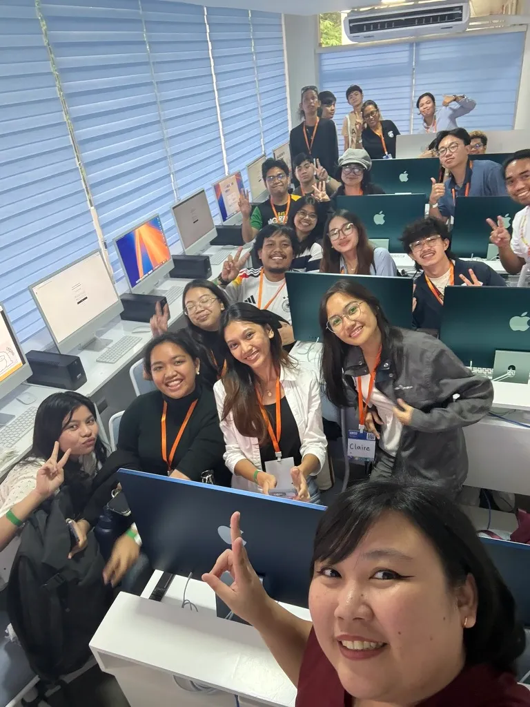 Chi doing a wide angle selfie with the attendees of her workshop while at UXPH Mini 2025: Cebu in a small classroom that was fully seated.